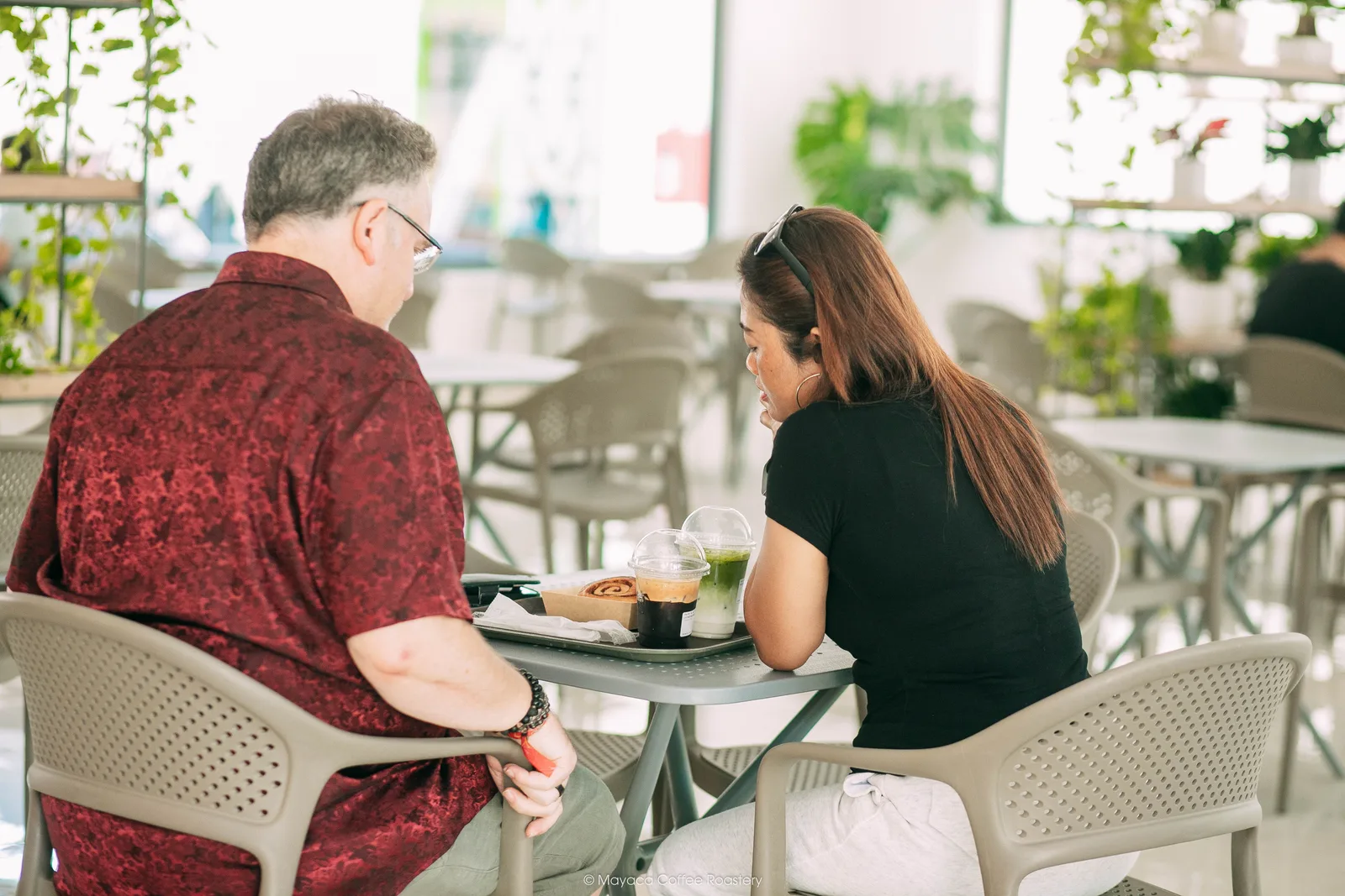 Hai khách hàng trò chuyện bên bàn tại Hai Linh Coffee